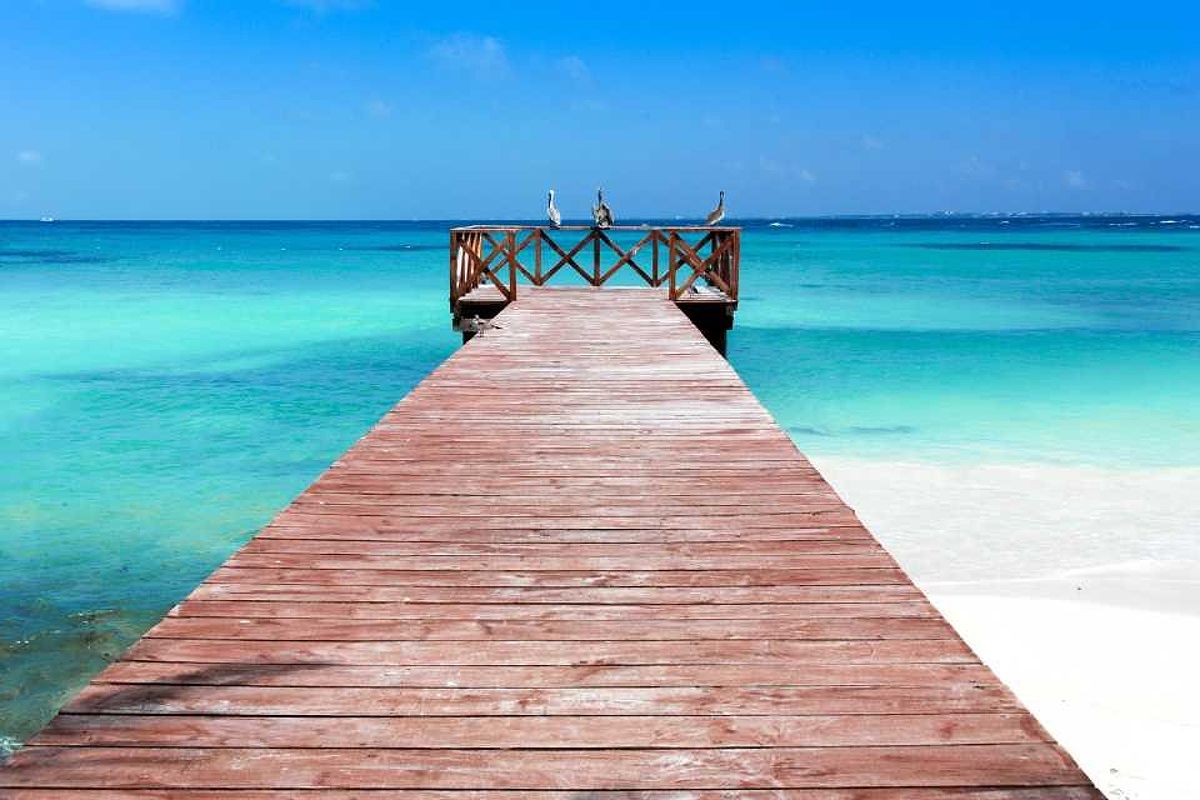 A boardwalk extends out from a Cancun beach